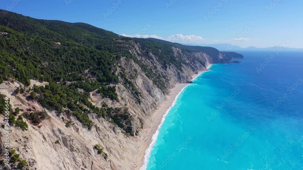 Aerial drone video of tropical paradise island covered in pine trees with turquoise crystal clear beach in paradise island destination resembling a blue lagoon Aerial drone video of tropical paradise island covered in pine trees with turquoise crystal clear beach in paradise island destination resembling a blue lagoon