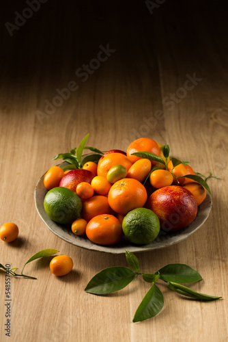 A large plate of fruits on a wooden table