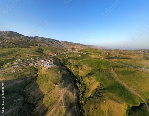 Aerial view of a rural village area with mountains and trees