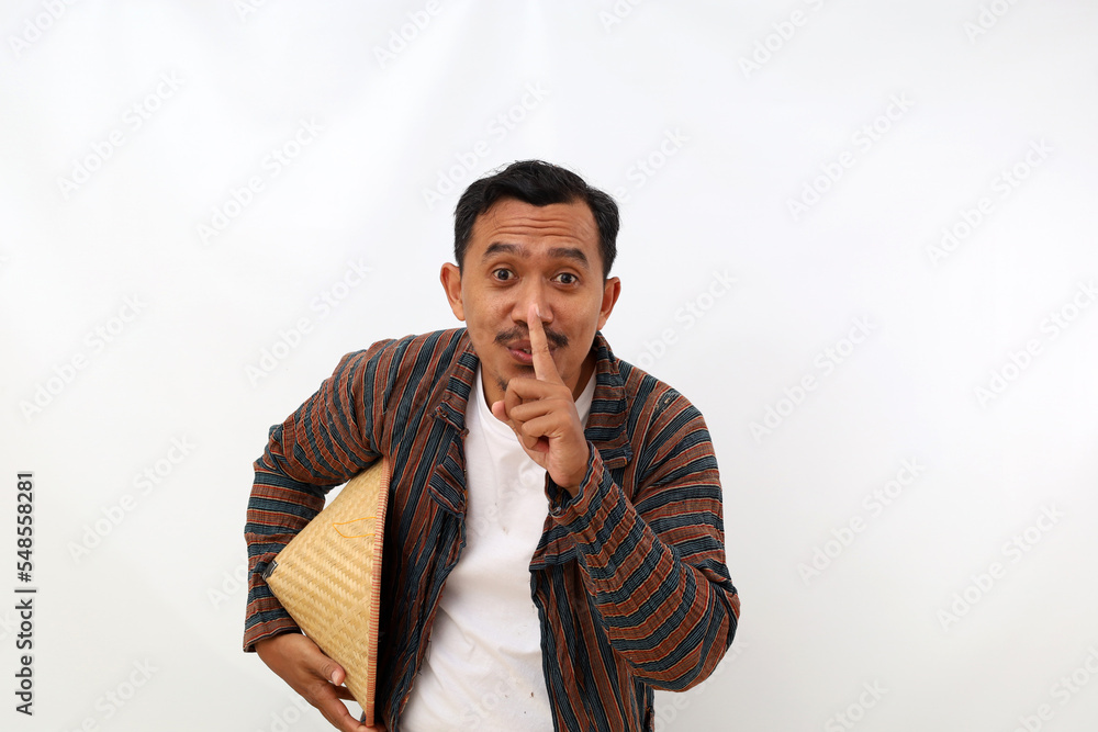 Funny asian farmer standing with telling secret hand gesture. Isolated on white background Funny asian farmer standing with telling secret hand gesture. Isolated on white background