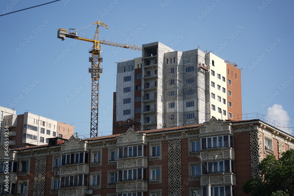 Almaty, Kazakhstan - 04.26.2022 : A residential building with an old design and a new residential complex under construction