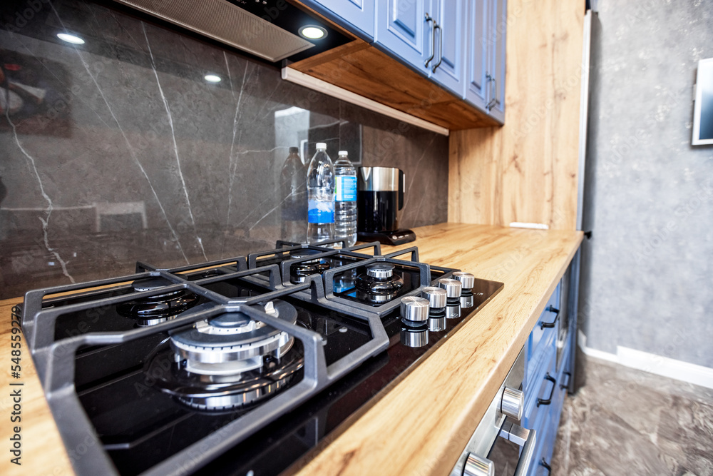 Modern kitchen in the Art Nouveau style. Wooden countertop and blue facade of kitchen furniture. Appliances. Modern kitchen in the Art Nouveau style. Wooden countertop and blue facade of kitchen furniture. Appliances.