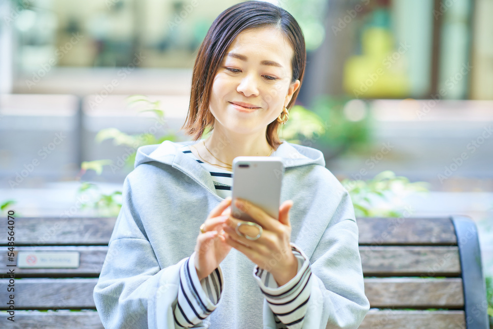 スマートフォンの画面を見る女性 スマートフォンの画面を見る女性