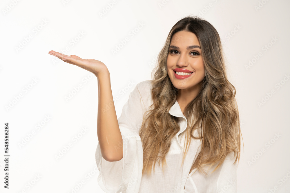 portrait of a young happy woman with long wavy hair nad makeup advertise some product on a white background portrait of a young happy woman with long wavy hair nad makeup advertise some product on a white background