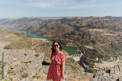 Woman in a dress standing in front of the green landscape with a river in Portugal photo