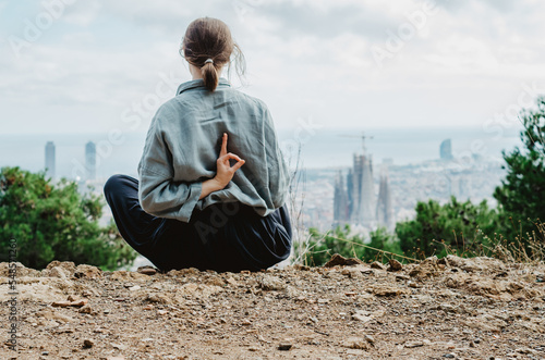 Photography Woman seated showing ok sign at back looking at panoramic Barcelona