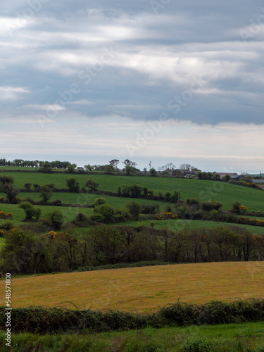 Picturesque Irish hills under a beautiful cloudy sky. Irish nature, spring landscape. Green grass field under white clouds