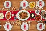 Christmas, party and food with a festive feast on a dinner table in a home from above for celebration. Chicken, event and nutrition with a meal setting on a wooden surface in the holiday season