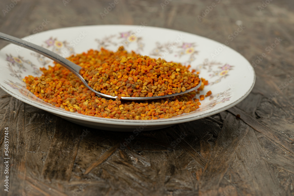 close up of a plate full of pollen on a wooden table close up of a plate full of pollen on a wooden table