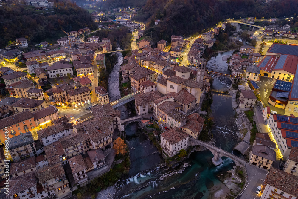 Aerial villagescape - old church and crossing rivers with mountains backdrop
