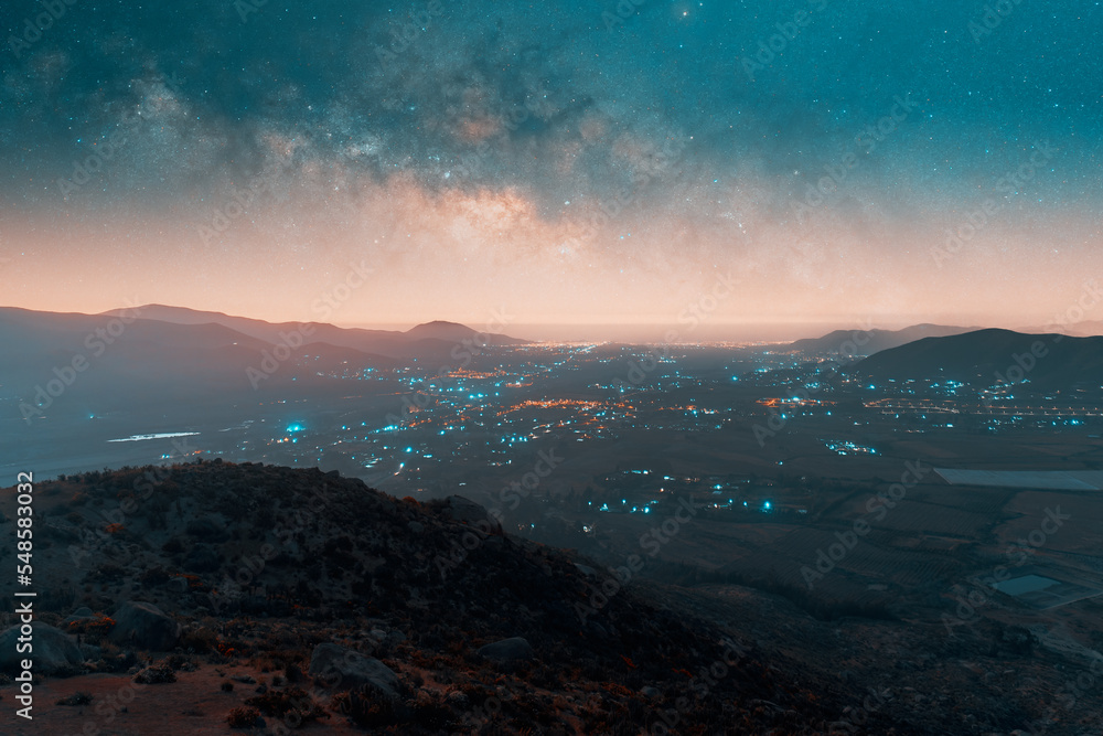 aerial panoramic view of the milky way over the city in the valley at night