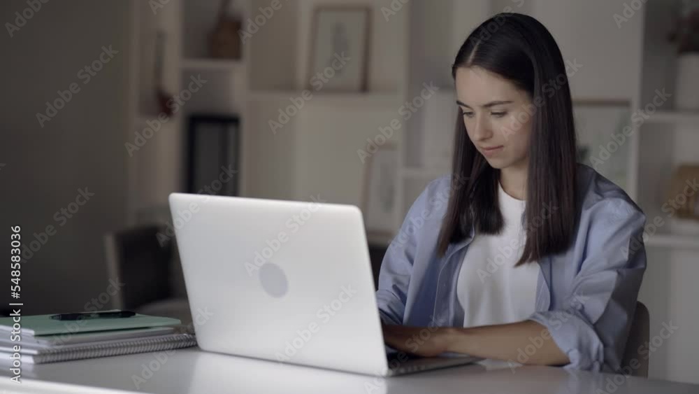 Female student doing homework from home using laptop and typing on keyboard, young business woman talking to colleagues via messenger on her remote computer at her desk at home office Female student doing homework from home using laptop and typing on keyboard, young business woman talking to colleagues via messenger on her remote computer at her desk at home office