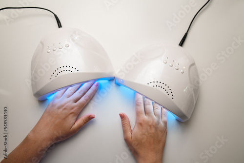 Bilde på lerret Close-up top view of hands into uv lamp for curing top cover of nail polish