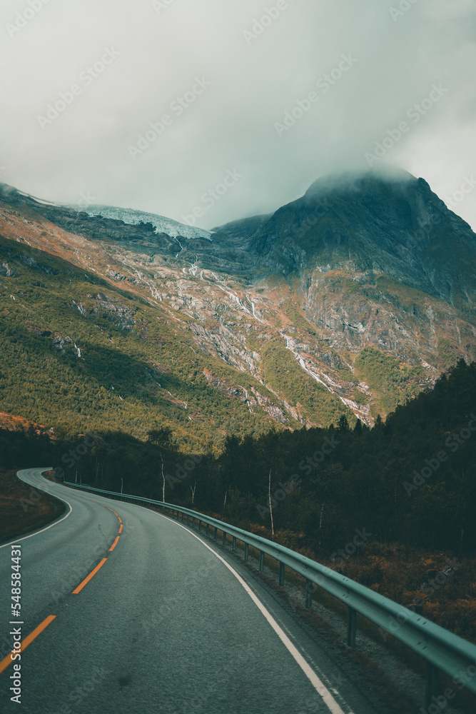 Naklejka premium Empty road leading towards mountains on a moody autumn day in Norway