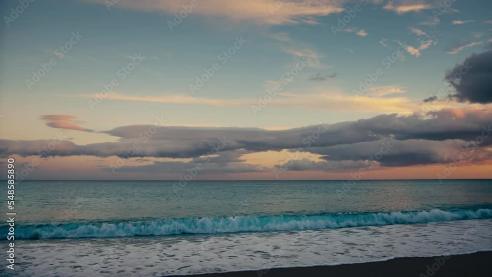 Calm waves of ocean and cloudy sunset sky Calm waves of ocean and cloudy sunset sky