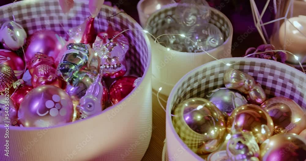 Close-up of Christmas decorations in a box. A woman's hand takes Christmas balls Close-up of Christmas decorations in a box. A woman's hand takes Christmas balls