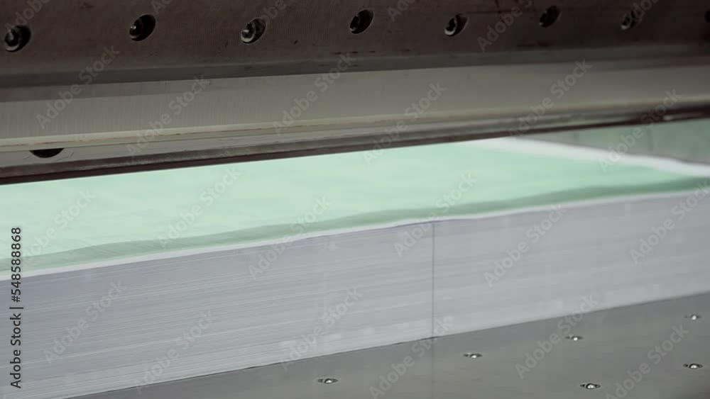 Worker cutting paper using paper cutting machine in a printing house close up. 4K resolution video Worker cutting paper using paper cutting machine in a printing house close up. 4K resolution video