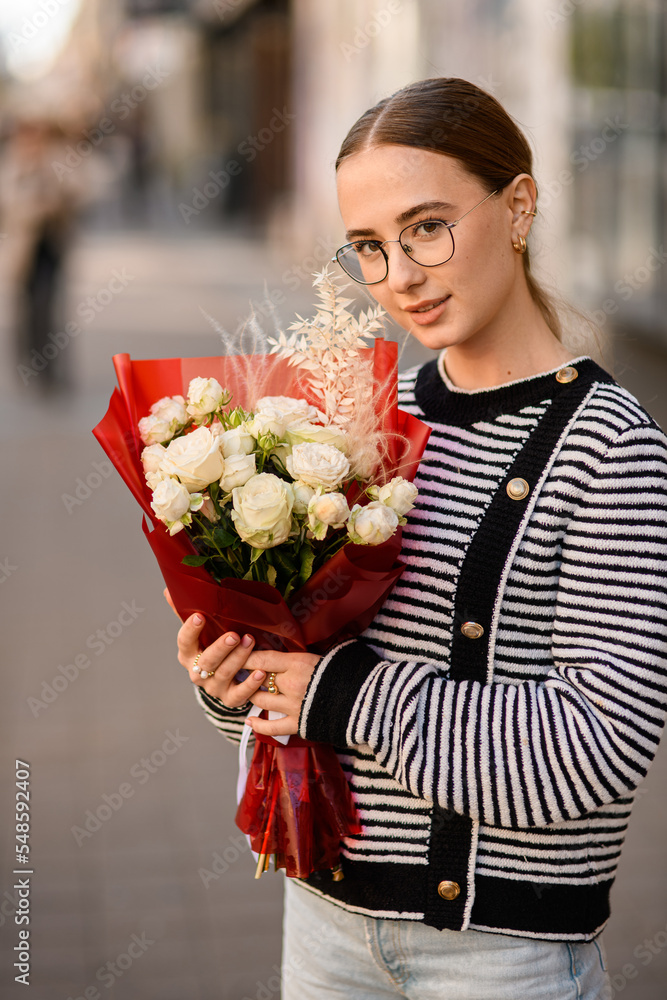 Fototapeta premium view on pretty woman with bouquet of white roses in her hand
