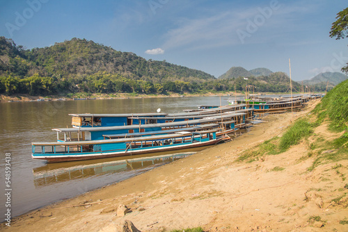 Photo Traditional lao sampan wooden boats at Mekong river bank