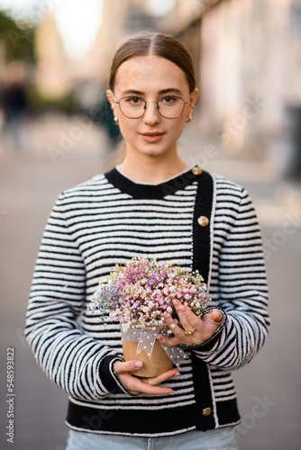 great portrait of woman holding pot with colorful gypsophila flowers in her hands