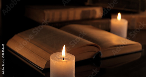 An old book and burning candles