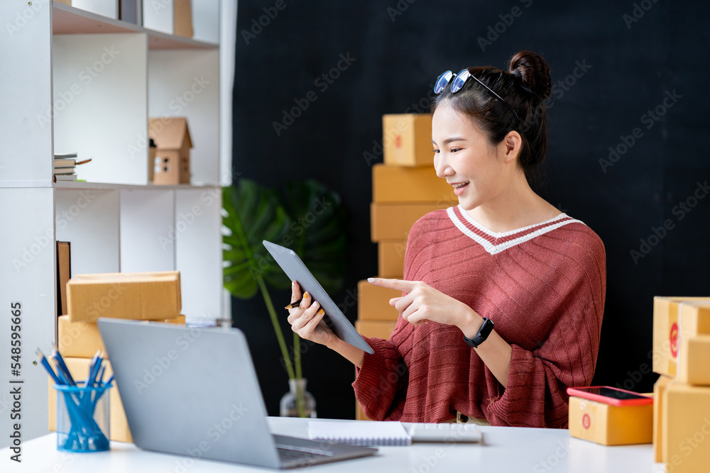 Portrait of an Asian businesswoman pressing a calculator, looking at a notebook, analyzing data, and reports, preparing presentations, marketing, and finance for sales in online shopping systems. Portrait of an Asian businesswoman pressing a calculator, looking at a notebook, analyzing data, and reports, preparing presentations, marketing, and finance for sales in online shopping systems.
