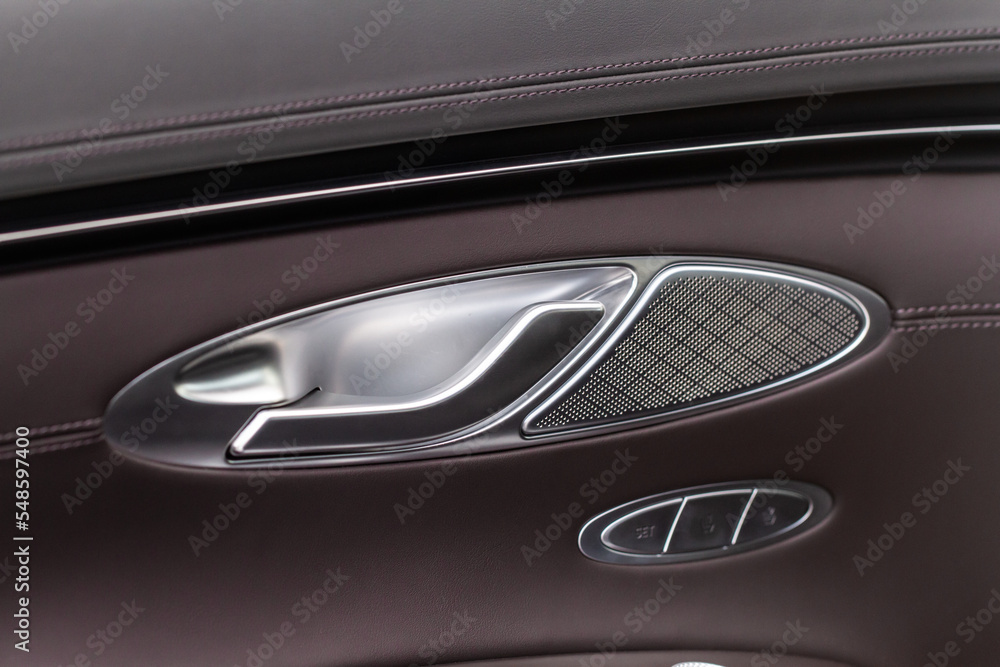 Naklejka premium Modern car interior door handle close up. Metallic Car door opener handle inside.