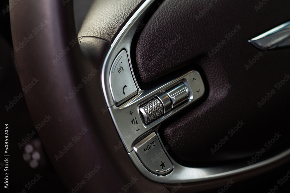 Obraz premium Call buttons on car steering wheel. Audio control buttons on the steering wheel of a modern car.