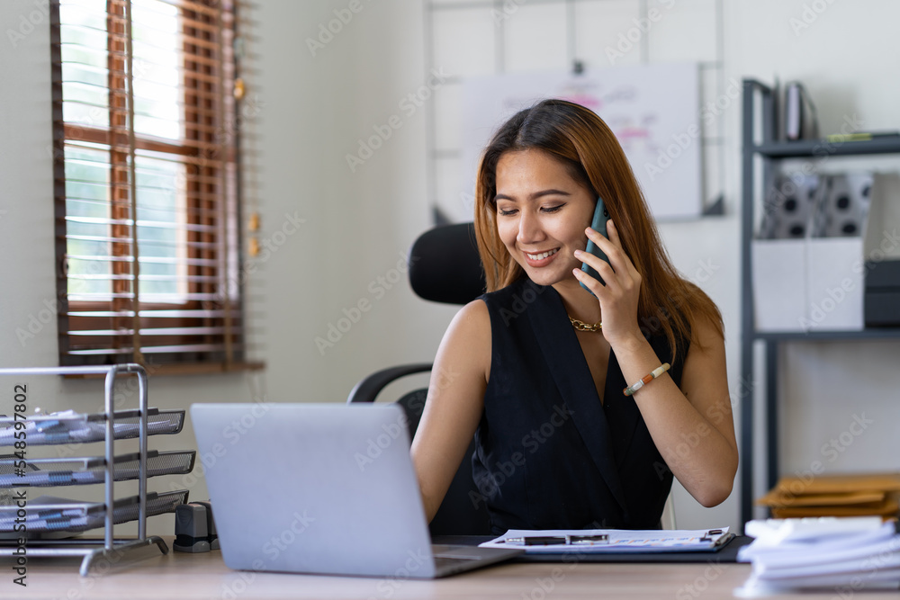 Portrait of an Asian businesswoman using a mobile phone while checking email or social media on the Internet. concepts of finance, accounting, and marketing. Portrait of an Asian businesswoman using a mobile phone while checking email or social media on the Internet. concepts of finance, accounting, and marketing.