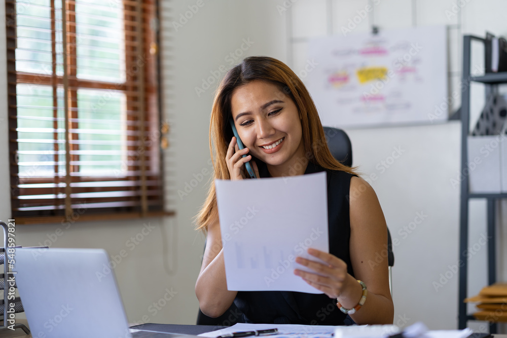 Portrait of an Asian businesswoman using a mobile phone while checking email or social media on the Internet. concepts of finance, accounting, and marketing. Portrait of an Asian businesswoman using a mobile phone while checking email or social media on the Internet. concepts of finance, accounting, and marketing.