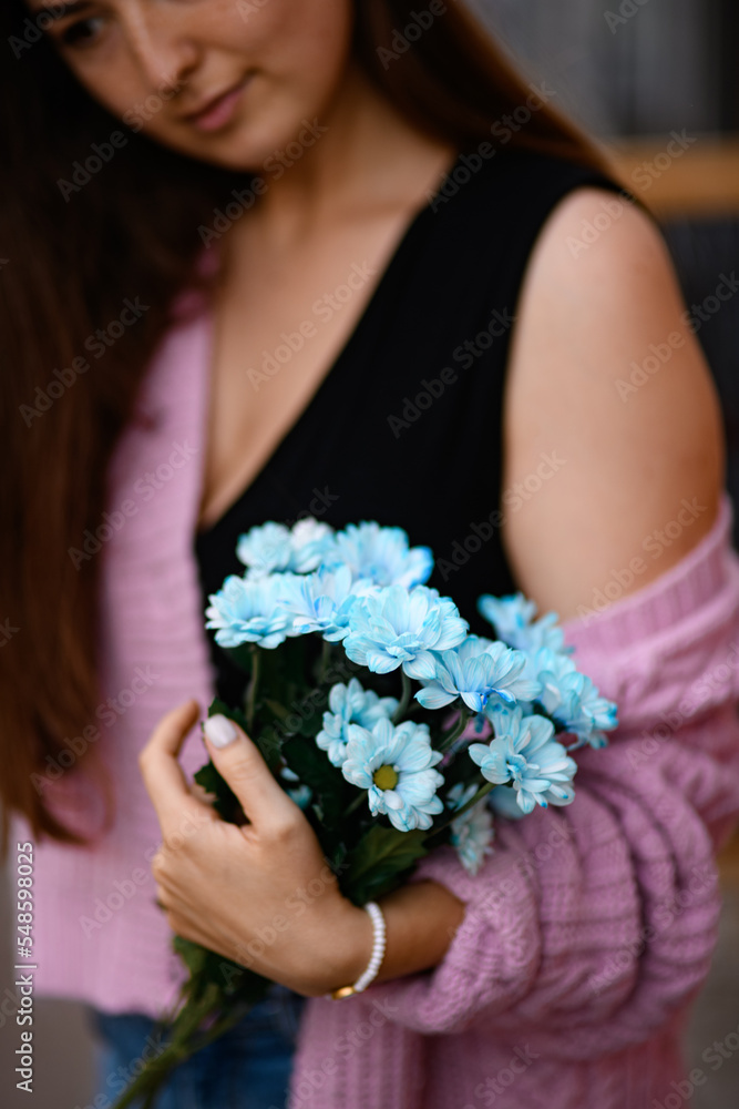 selective focus on blue chrysanthemums in the hands of woman