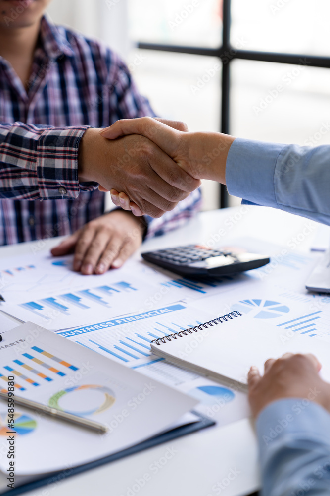 Young Asian businessmen and women shake hands as a team or greet each other at the office after a project. Successful in real estate business, finance, and new business ideas. Young Asian businessmen and women shake hands as a team or greet each other at the office after a project. Successful in real estate business, finance, and new business ideas.