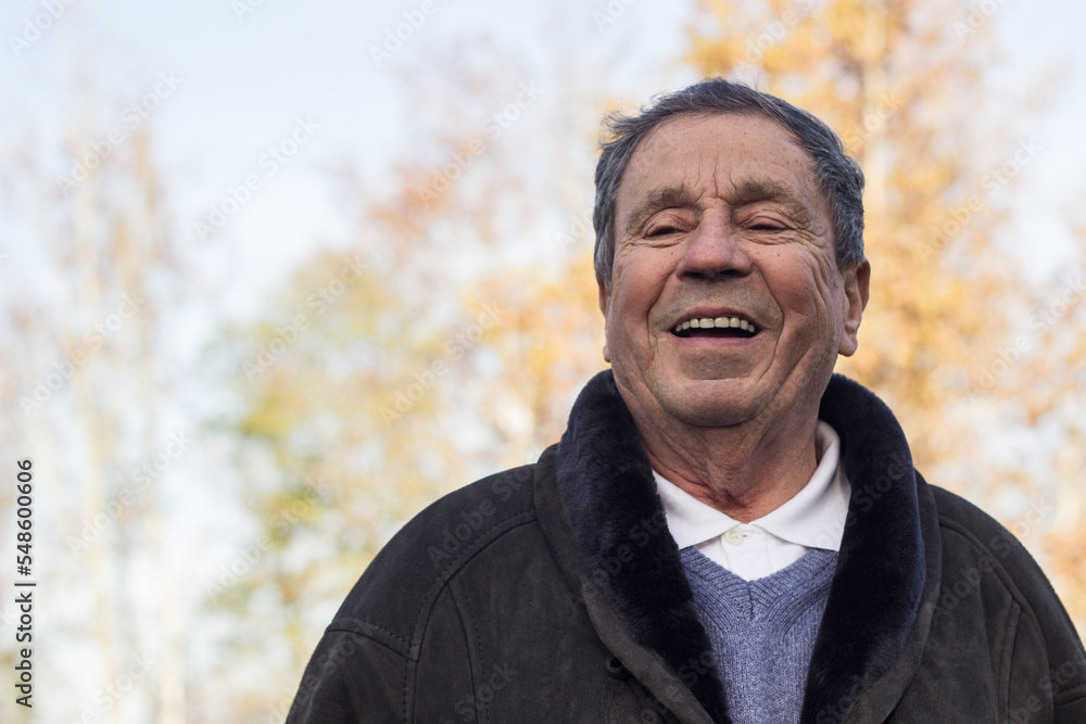 A smiling and satisfied elderly man walking through the park A smiling and satisfied elderly man walking through the park