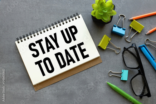 Fotografie stay up to date. different stationery and text on notepad.