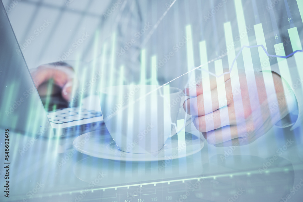 Double exposure of graph with man typing on computer in office on background. Concept of hard work. Double exposure of graph with man typing on computer in office on background. Concept of hard work.