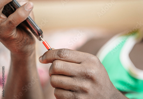 Close-up of hand of young black man charging phone