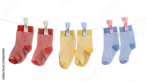 Vászonkép Stylish baby socks hanging on clothesline against white background