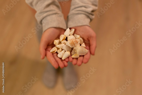 a woman is holding seashells in her hand. wellness