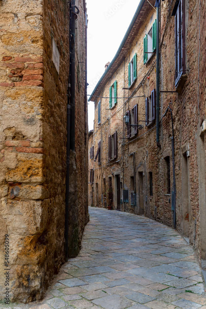 An old narrow street and louvered windows and stone houses in northern Italy