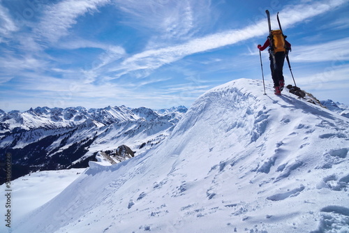 Skitour, Skibergsteiger im Aufstieg am Gipfel