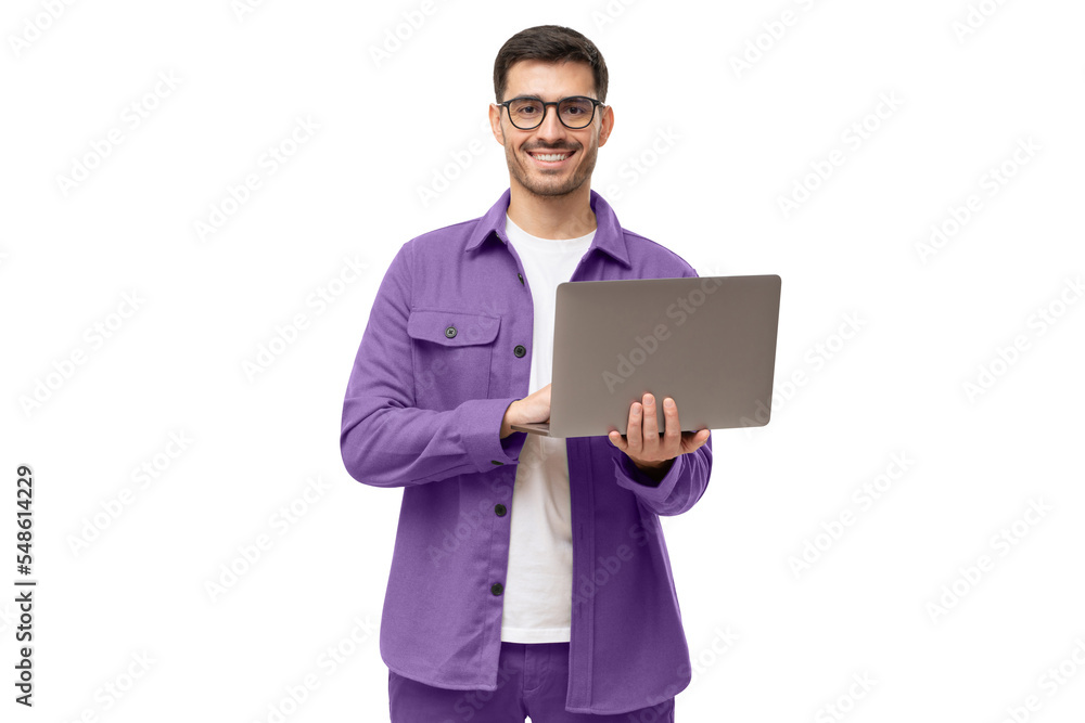 Young man standing in casual purple shirt, holding laptop and looking at camera with happy smile