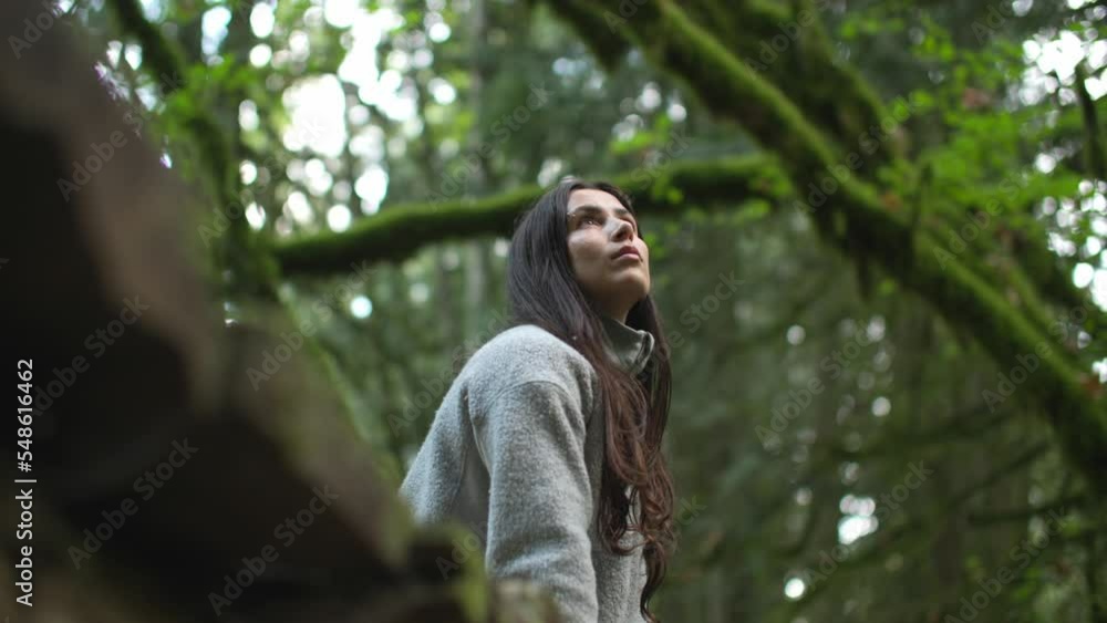 Girl relaxes in lush green forest and takes in scenery Girl relaxes in lush green forest and takes in scenery