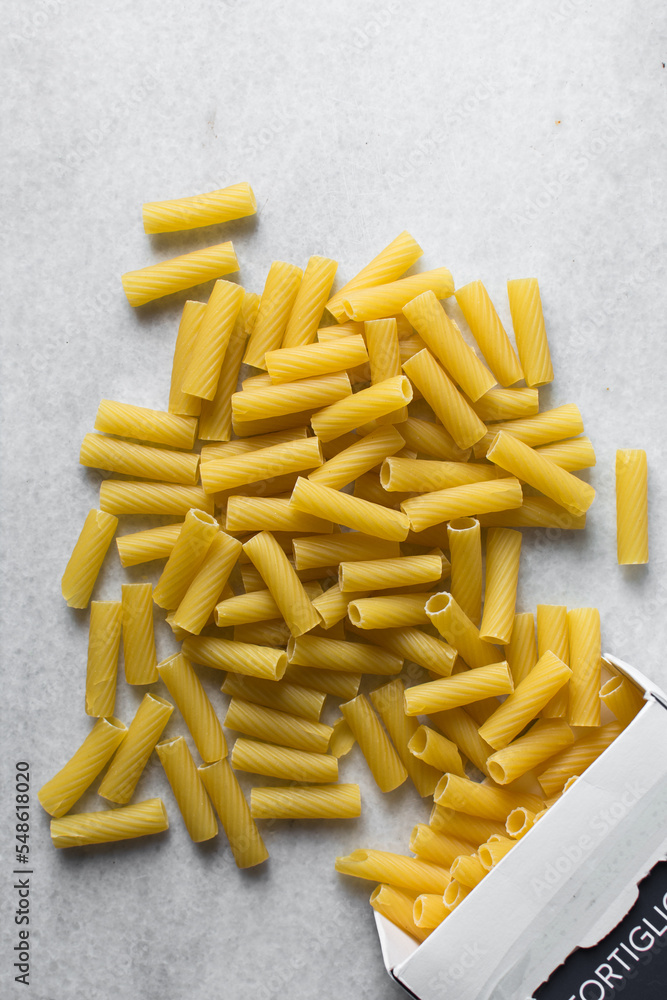 Flat lay of uncooked tortiglioni pasta shells, top view of tortiglioni pasta shells, dry uncooked macaroni Flat lay of uncooked tortiglioni pasta shells, top view of tortiglioni pasta shells, dry uncooked macaroni