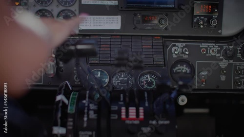 Female pilot touching controls in airplane cockpit, control center