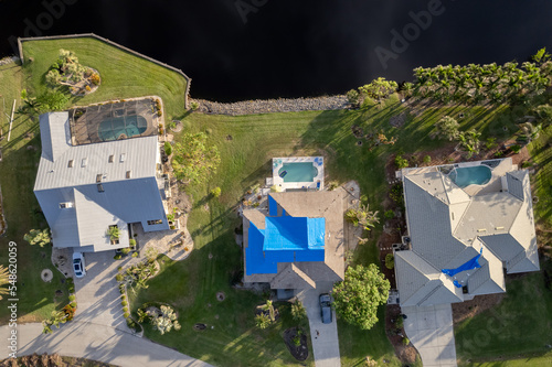 Wallpaper Mural Hurricane Ian destroyed homes in Florida residential area blue tarp roof. Natural disaster and its consequences Torontodigital.ca