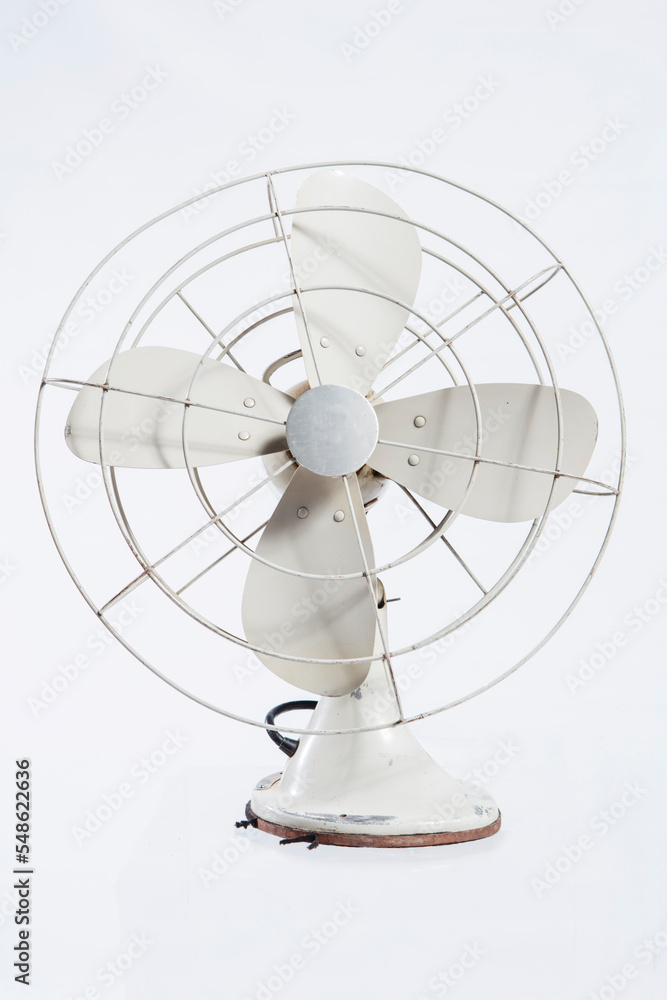 Old, battered and bent but this rustic antique electric fan still works. White background with copy space.