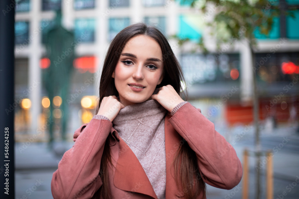 Portrait of a model in a sweater with a collar in urban locations on a blurred background.