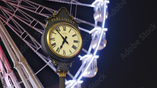 Timelapse of Bucharest Parliament public clock with Christmas ferris wheel in the back, at night, in the capital of Romania.