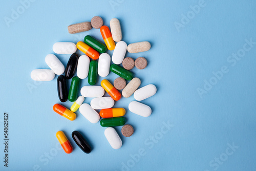 Top view of different pills on blue background,copy space for text,backdrop with copy space.