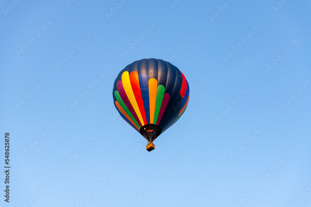 A colorful hot air balloon high in the blue sky. A colorful hot air balloon high in the blue sky.